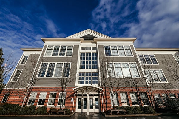 a three story building with a brick face on the lowest floor