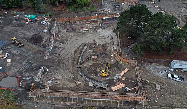 aerial view of construction site with a curved trnecy with pipes and a concrete frames with concrete in them