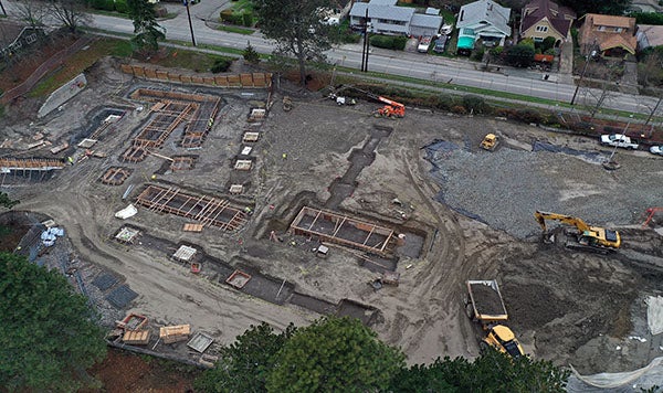 aerial view of a construction site with several rectangular holes lined with wooden frames