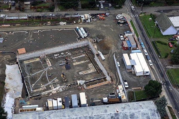 aerial view of a construction site with part of a concrete wall for a new building