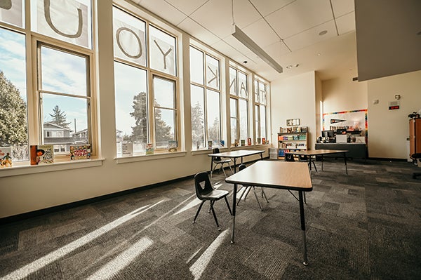 a large open space with windows, tables, and books