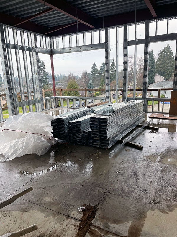 a concrete floor with a framed corner wall and a metal ceiling