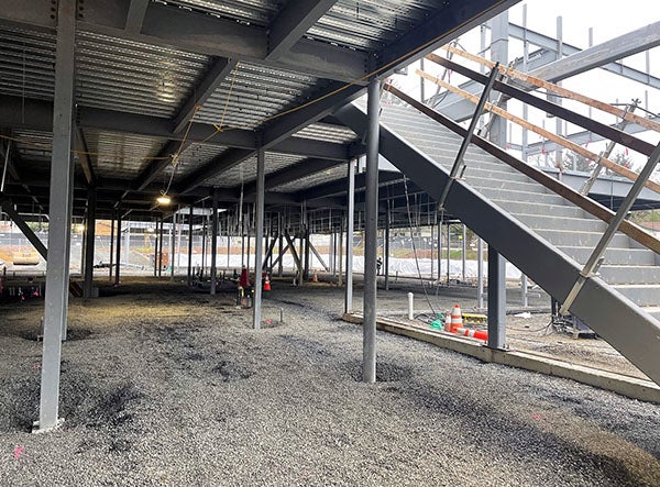 looking under a corrugated metal floor with stairs going up on the right hand side