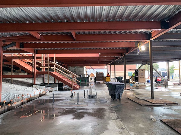 concrete floor under steel beams with metal over them; stairway up to the left