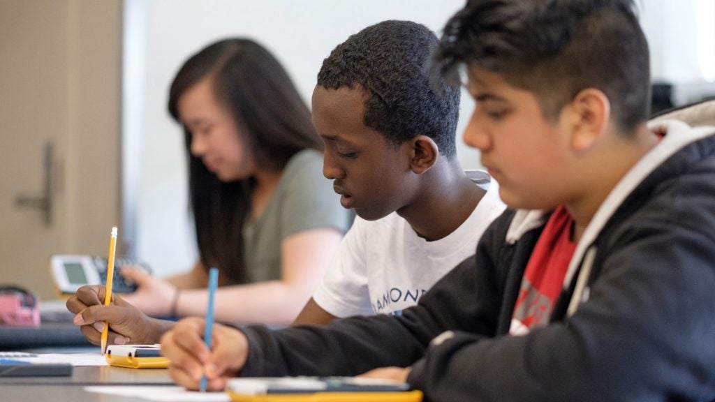 students writing at a desk