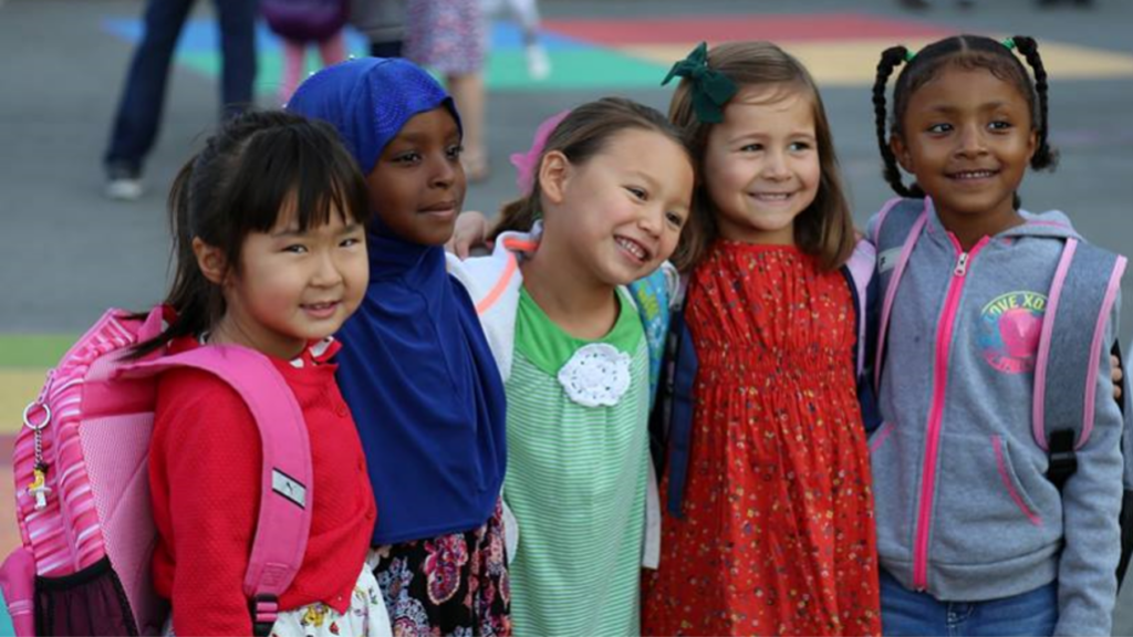 group of elementary students with arms around each other's shoulders