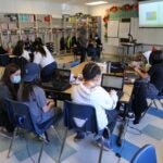 Students sitting at their desks researching on computers