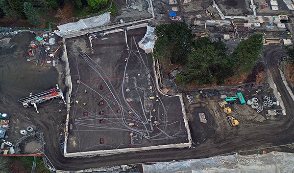 aerial view of a construction site with the building shape outlined with concrete walls
