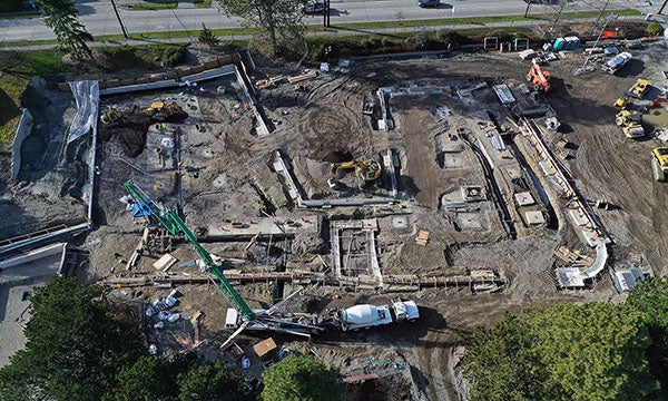 aerial view of a construction site with a concrete pumping truck installing concrete