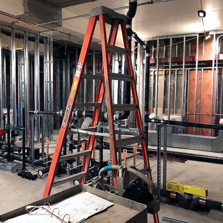 a room under construction with metal framing and a ladder