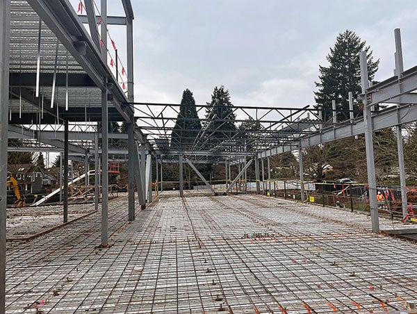 a steel framed building with joists installed at one end and a metal grid on the floor