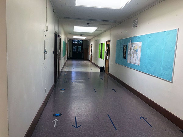 a corridor with a bulletin board on the wall and doors