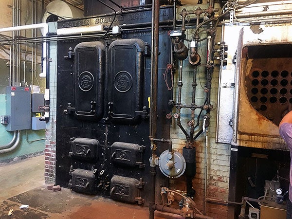 a large cast iron boiler with pipes coming out of it
