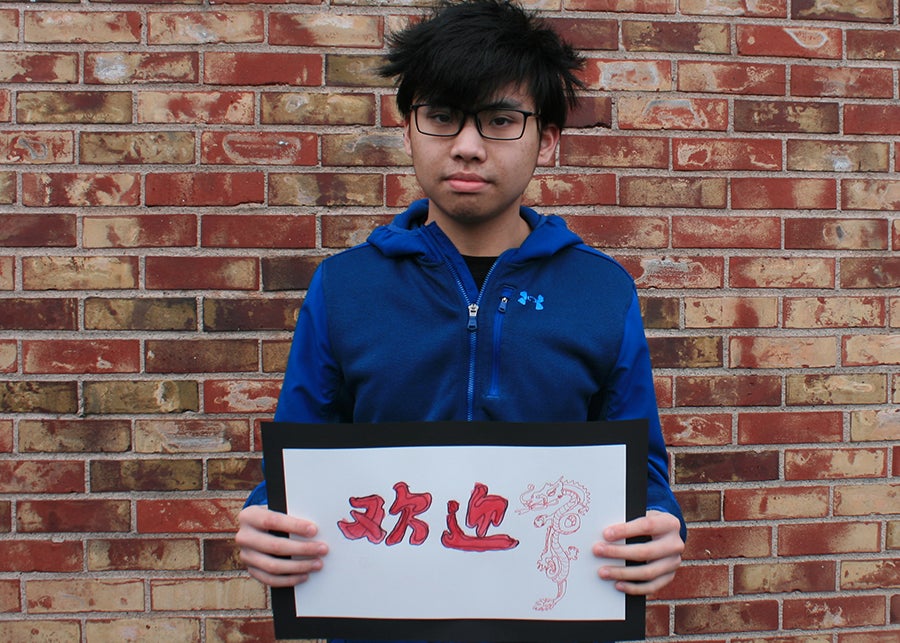A student holding a welcome sign