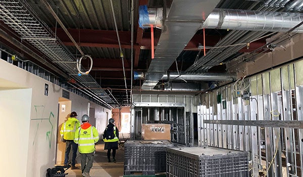 interior of a buiding under construction with duct work and wiring shelves