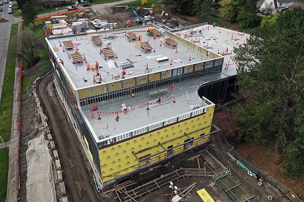 aerial view of a large building under construction with a roof and yellow material on walls