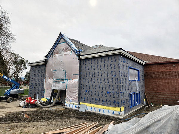 a partially buillt 2 story building with plastic over the entry