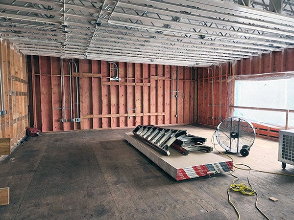 interior of a room under construction with studs and electrical lines