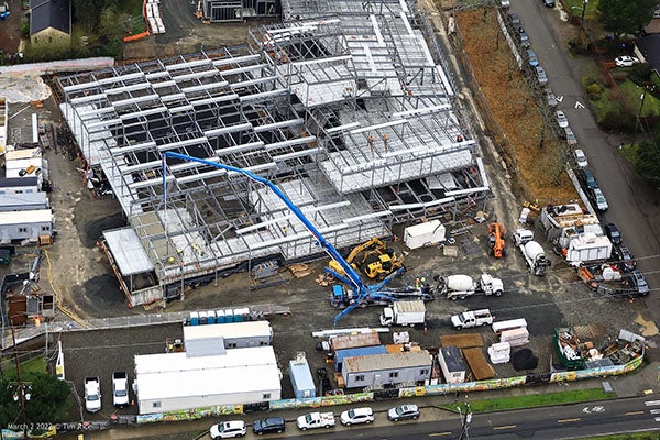 concrete being pumped into a steel framed building under construction