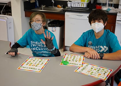 Two students in a classroom pose for a photo