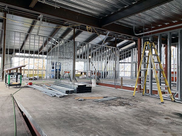 inside of a building under construction with metal wall studs and the underside of a metal roof