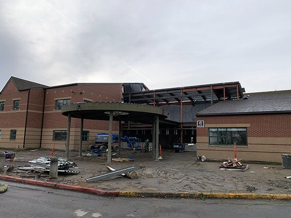 a brick building has a round canopy under construction in front of it