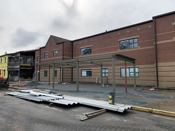 a brick building has a steel frame structure in front of it