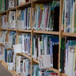 A school library shelf with many books in alphabetical order