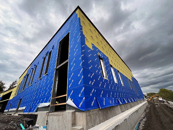 blue material on the outside ofa two story building under construction
