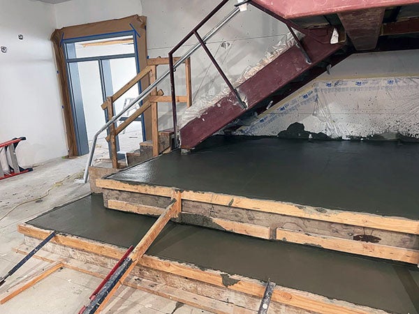 a stair under construction with fresh poured concrete below it