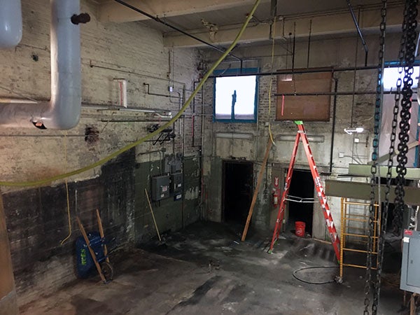 a concrete block room with a concret floor and a ladder