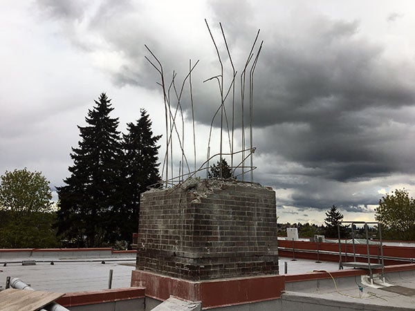 A brick chimney that has had about 2/3 of the brick removed