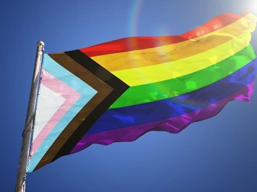 A Pride flag waves in the wind.