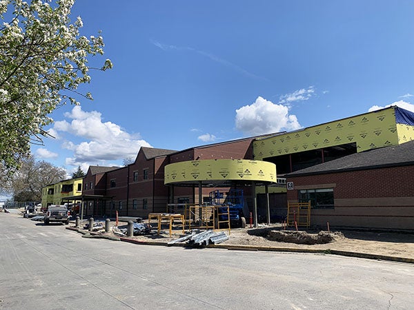 a brick building has a circular canopy and part of it under construction
