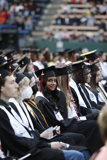 A graduate smiles for a photo during a graduation ceremony