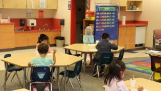 Jump Start students sit at their desks and color a piece of paper.