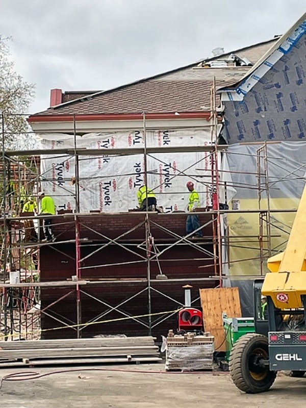 people on a scaffolding putting brick on a building