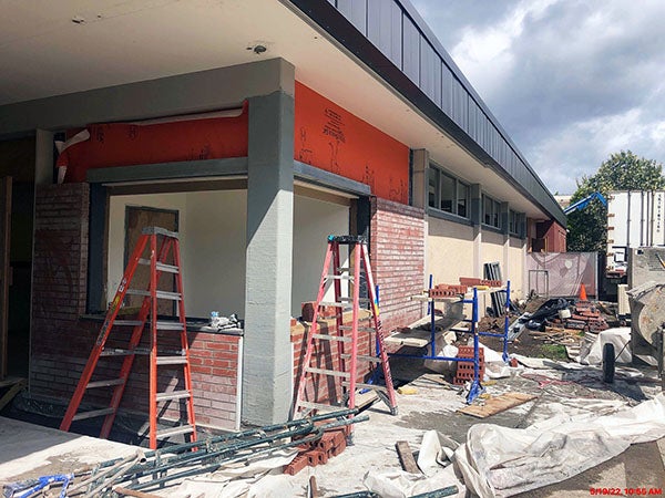 brick partly installed on the ground level of a building exterior