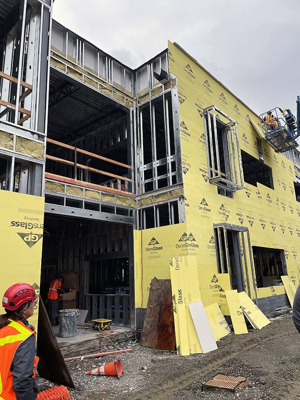 a partially built structure with yellow panels being installed