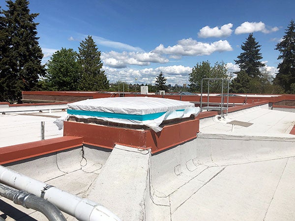 a roof with a square area framed and covered with plastic