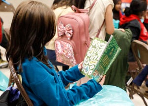 A student reads a book in a school auditorium 