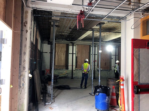 a person stands in a room under construction with metal posts