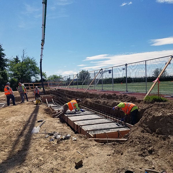 workers smoothing concrete in a frame