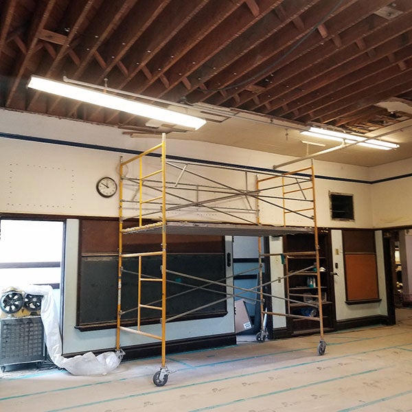 a classroom with no ceiling panels and a scaffolding