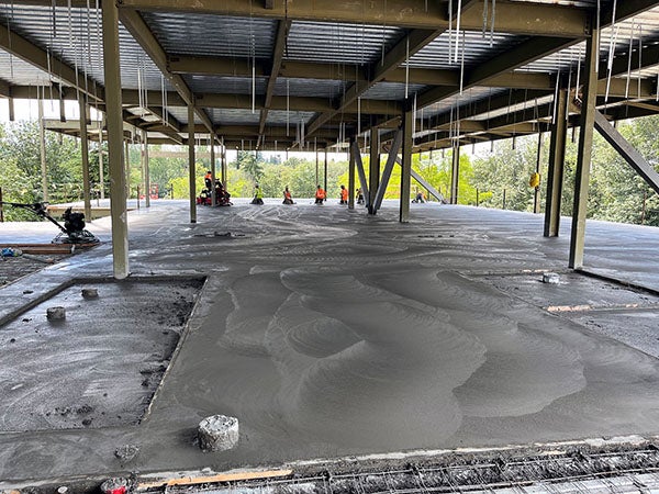 a concrete floor has people finishing soft concrete