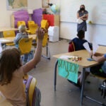 A teacher and students in a classroom during a summer program class