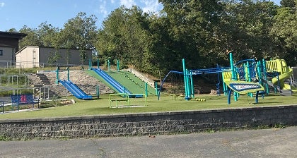 The school playground features several play structures and grassy area