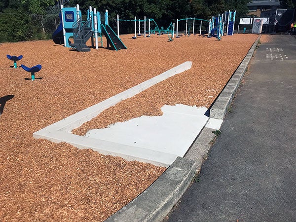 a curb cut and ramp to a play area