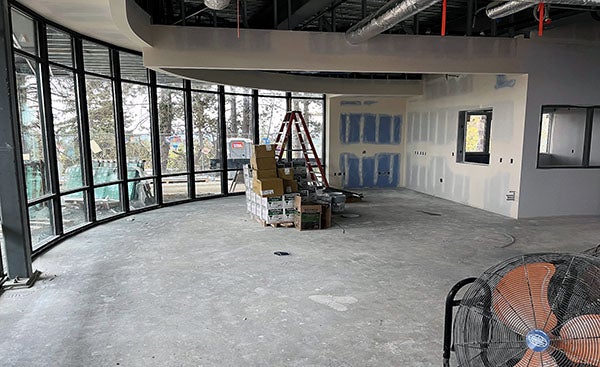 an interior room under construction with a curved wall of windows