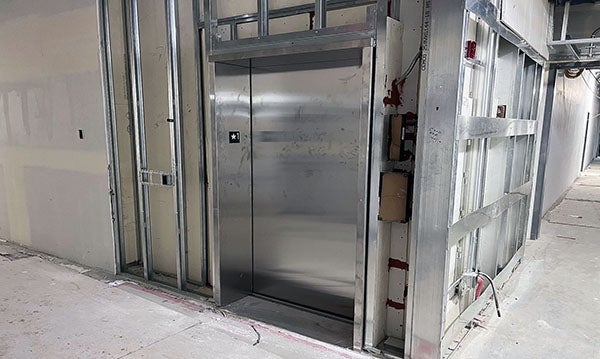 an elevator sites in a wall that is under construction